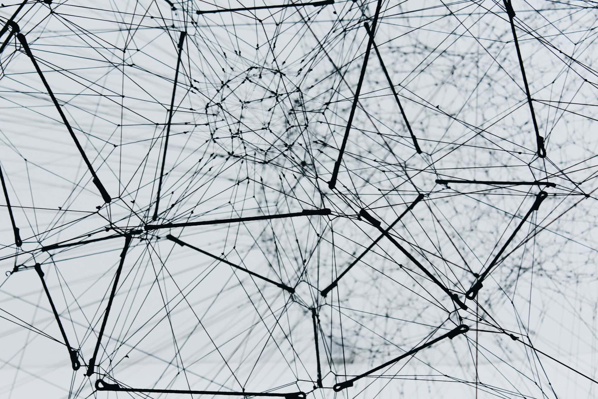 A monochrome image showing a complex network of wires, intricately intertwined and connecting various points.