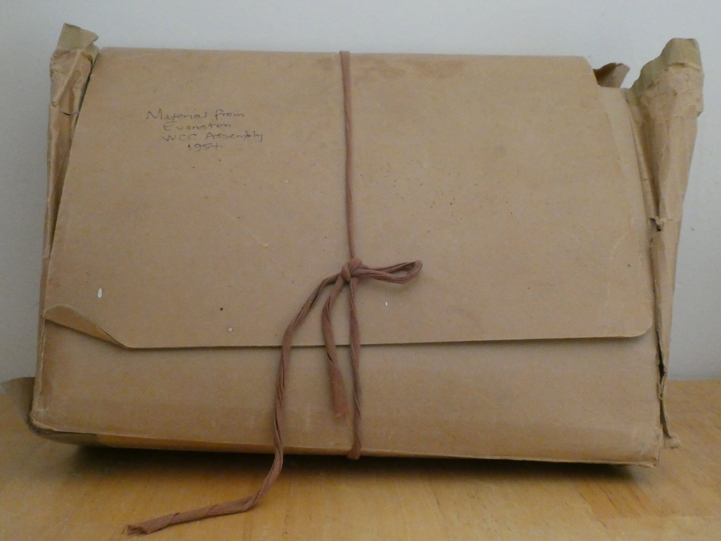 A brown accordion file, wrapped with brown string.